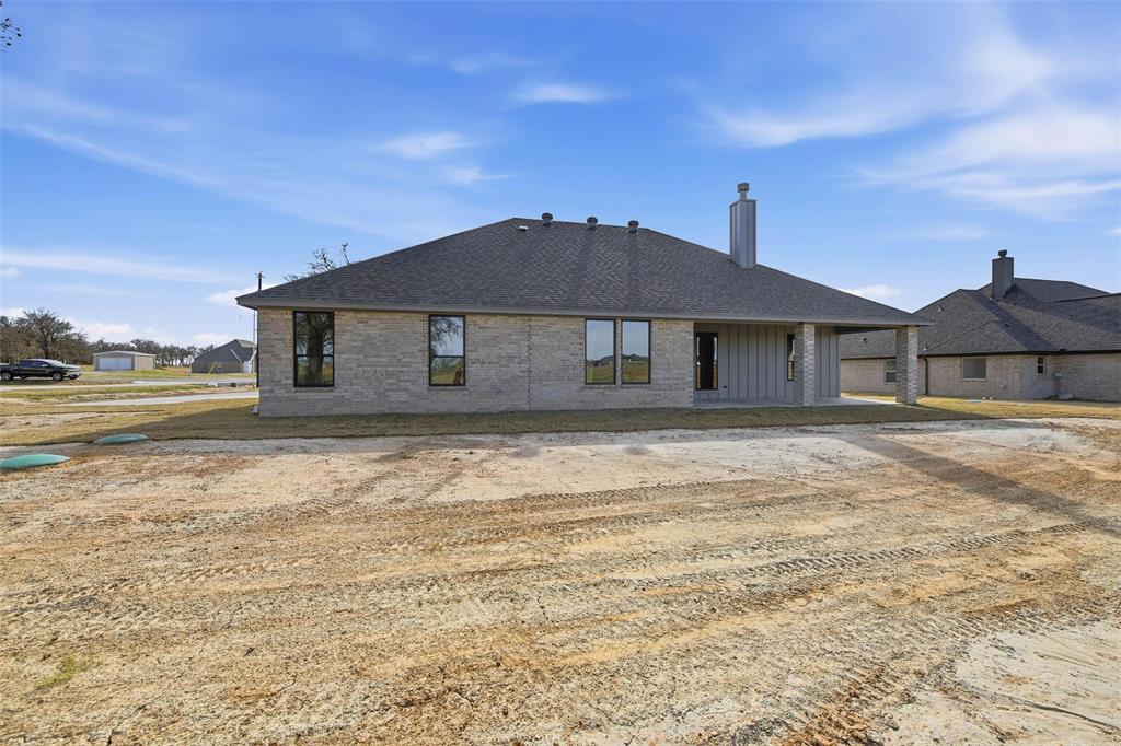 1973 Johnnie Drive Springtown, TX 76082 - Photo 35 of 38 Back of house with a patio, brick siding, roof with shingles, and a chimney