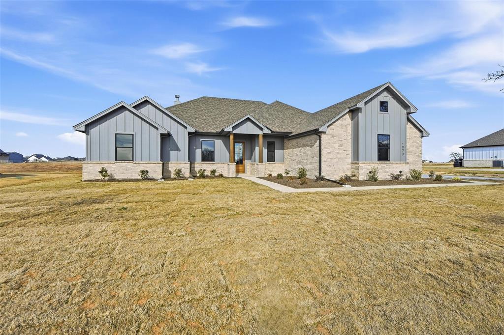 1973 Johnnie Drive Springtown, TX 76082 - Photo 4 of 38 Modern inspired farmhouse featuring board and batten siding, a front lawn, and stone siding
