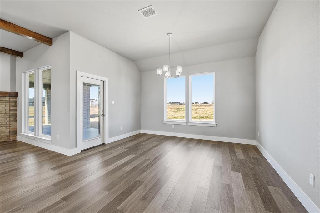 1973 Johnnie Drive Springtown, TX 76082 - Photo 10 of 38 Unfurnished room featuring a chandelier and wood finished floors