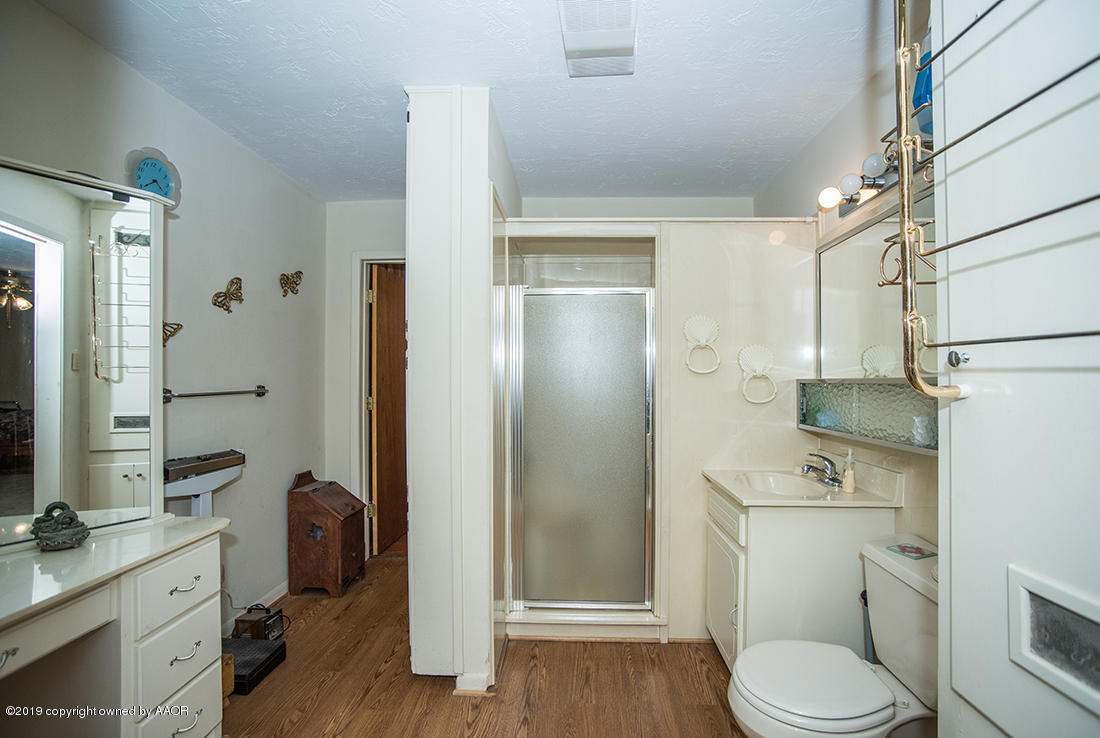 4404 South Hayden Street Amarillo, TX 79110 - Photo 15 of 29 a bathroom with a toilet a sink and shower