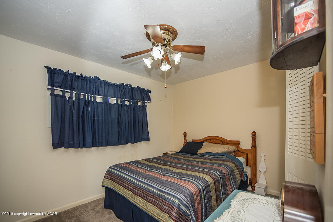 4404 South Hayden Street Amarillo, TX 79110 - Photo 18 of 29 a bedroom with a bed and a chandelier