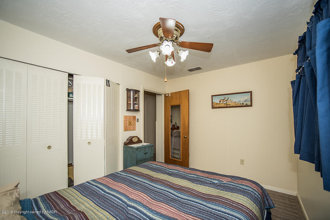 4404 South Hayden Street Amarillo, TX 79110 - Photo 19 of 29 a bedroom with a bed and a chandelier
