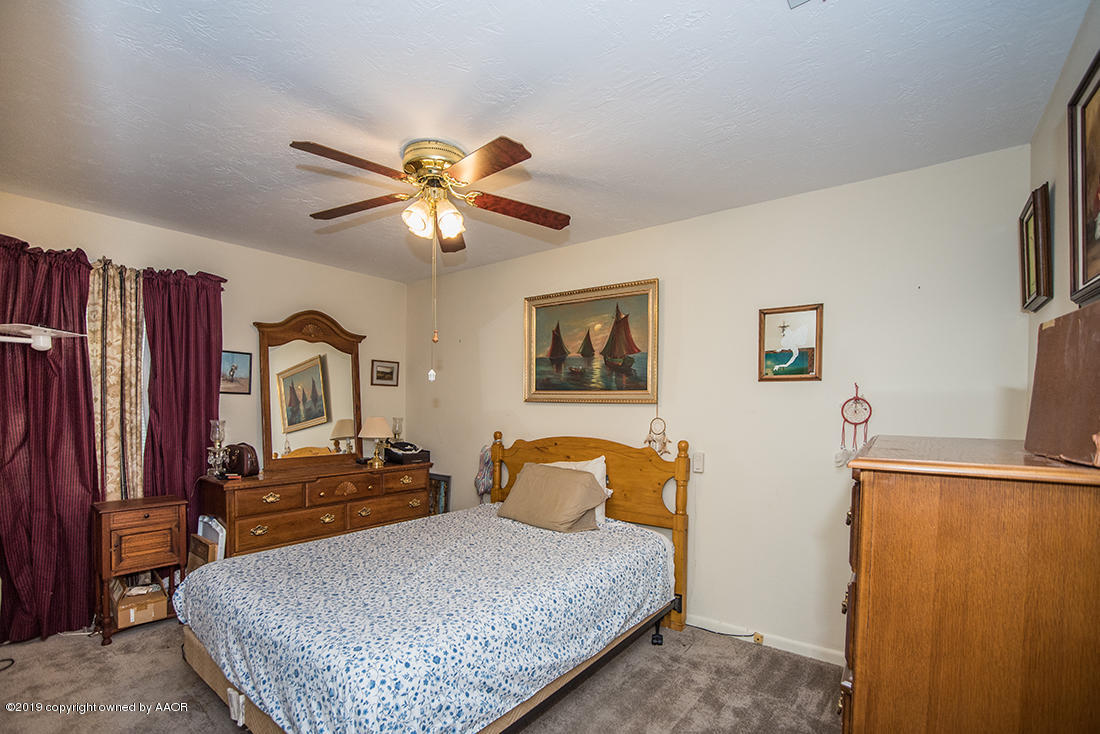 4404 South Hayden Street Amarillo, TX 79110 - Photo 20 of 29 a bedroom with a bed and a chandelier