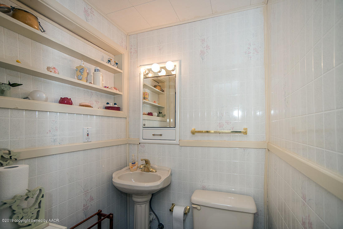 4404 South Hayden Street Amarillo, TX 79110 - Photo 26 of 29 a bathroom with a sink a toilet and mirror