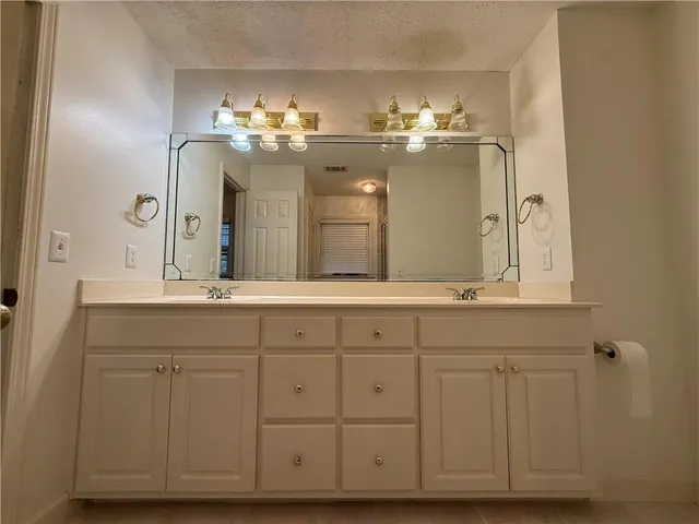 a bathroom with a double vanity sink and a mirror