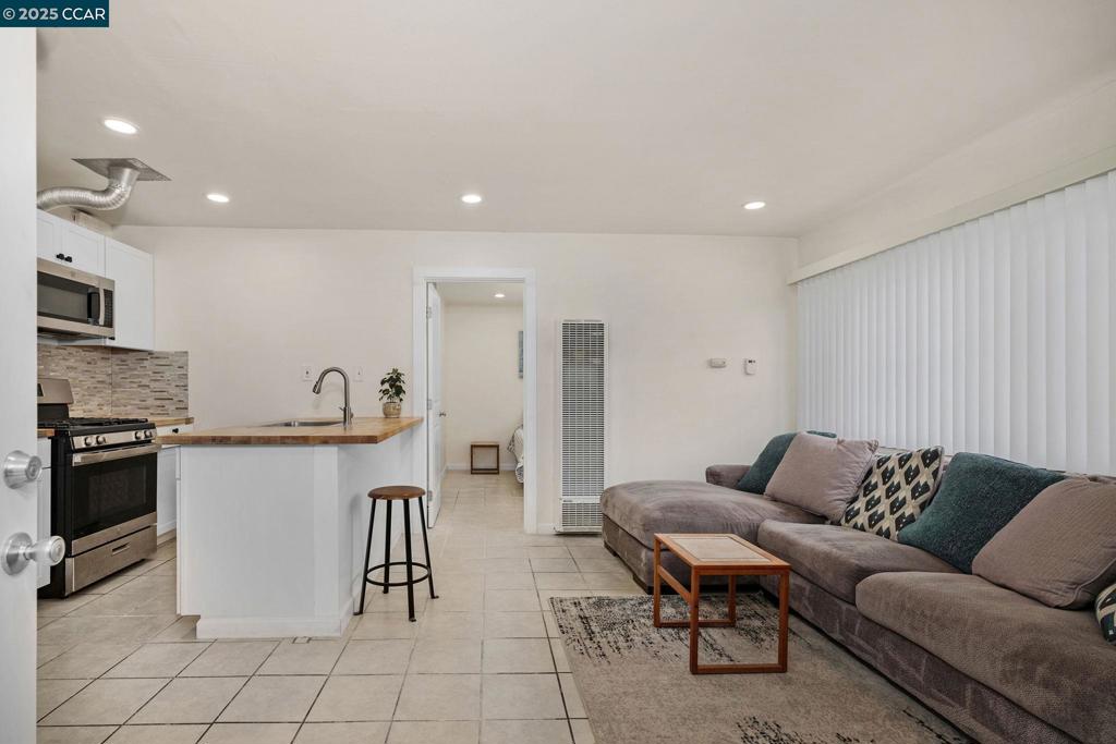 1926 Alcatraz Avenue Berkeley, CA 94703 - Photo 5 of 14 a living room with furniture a refrigerator and kitchen view