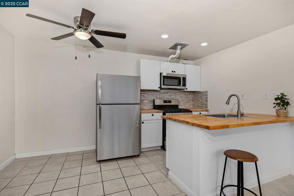 1926 Alcatraz Avenue Berkeley, CA 94703 - Photo 9 of 14 a kitchen with stainless steel appliances a refrigerator sink and microwave