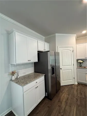 a kitchen with a refrigerator and a stove top oven