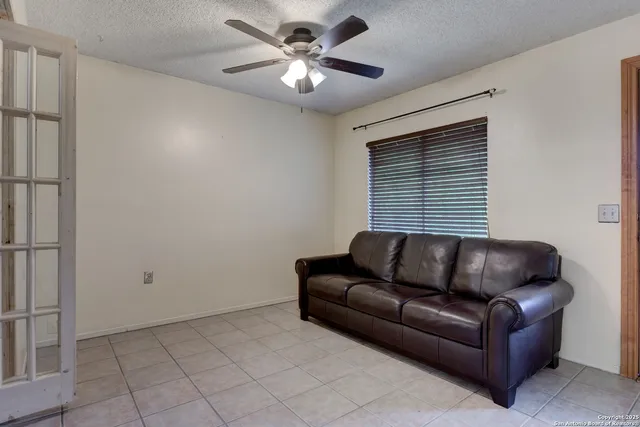a living room with furniture and a ceiling fan