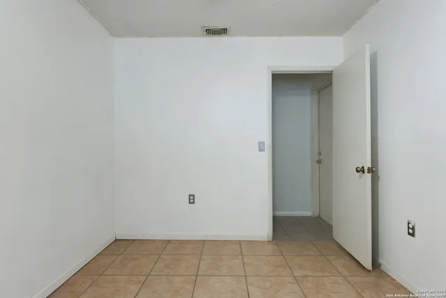 a white house with a small yard and large trees