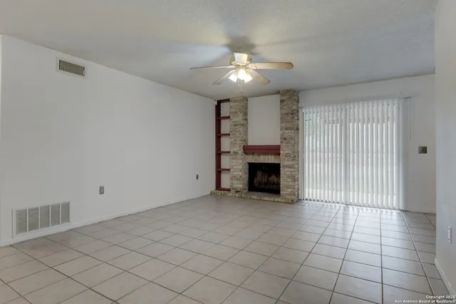 an empty room with fireplace and windows