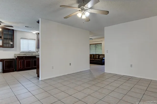 a kitchen with stainless steel appliances granite countertop a stove top oven a sink dishwasher and a refrigerator with wooden cabinets