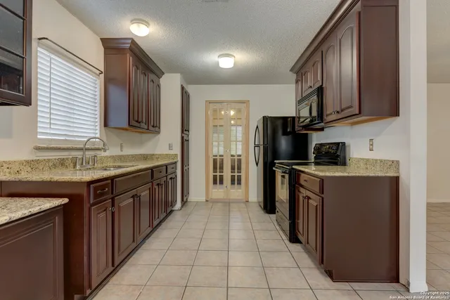 a kitchen with a sink a stove cabinets and a refrigerator