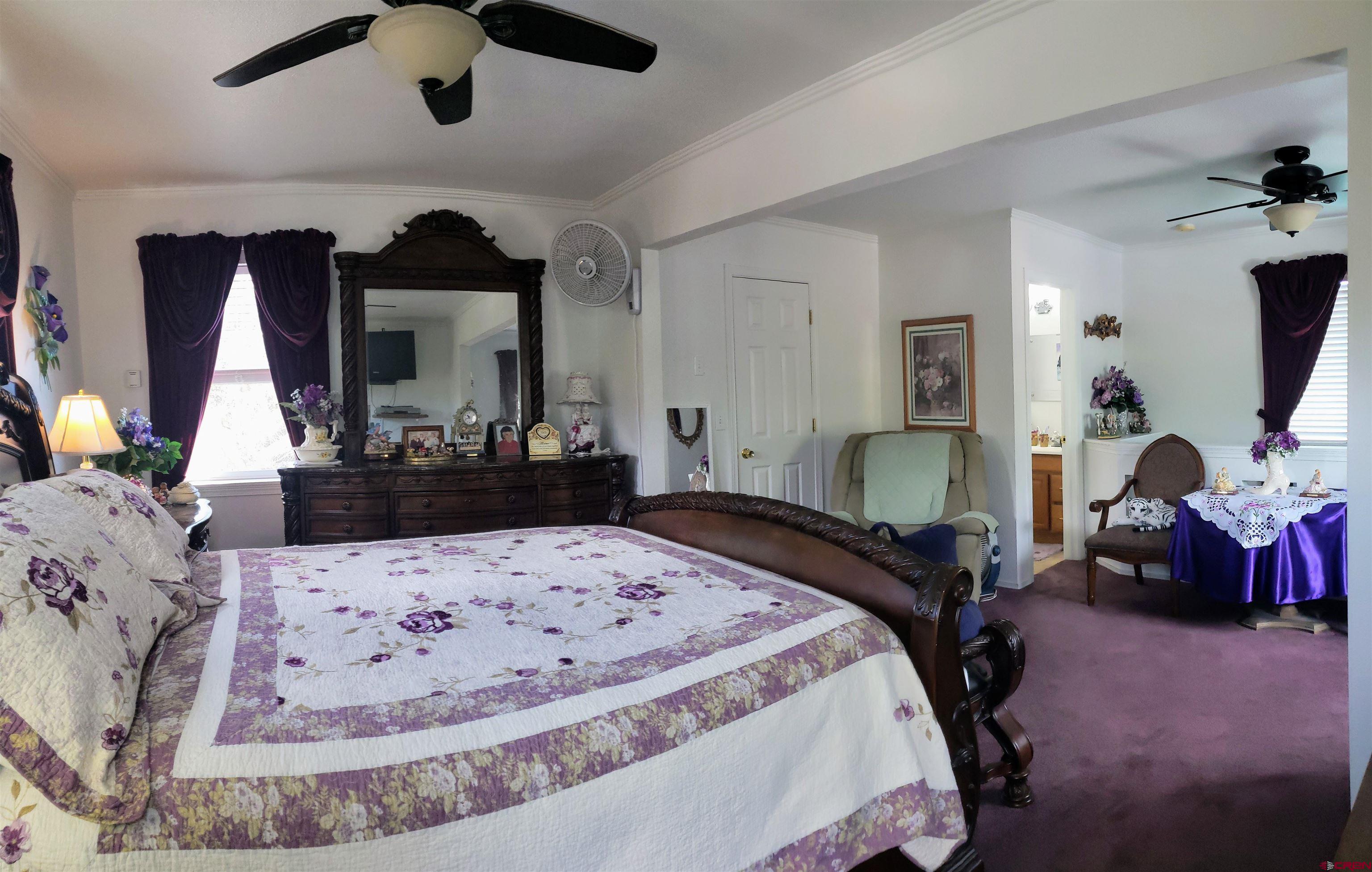 20915 Upland Road Cedaredge, CO 81413 - Photo 23 of 35 a bedroom with a large bed and a mirror on dresser