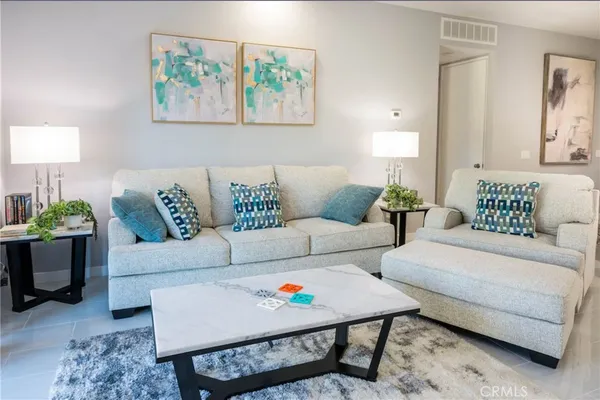 a living room with furniture and a painting on the wall