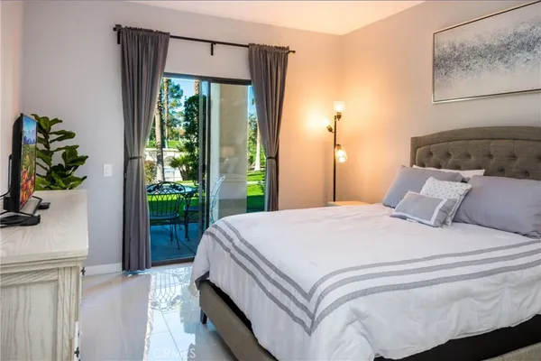 a bedroom with a bed mirror and table