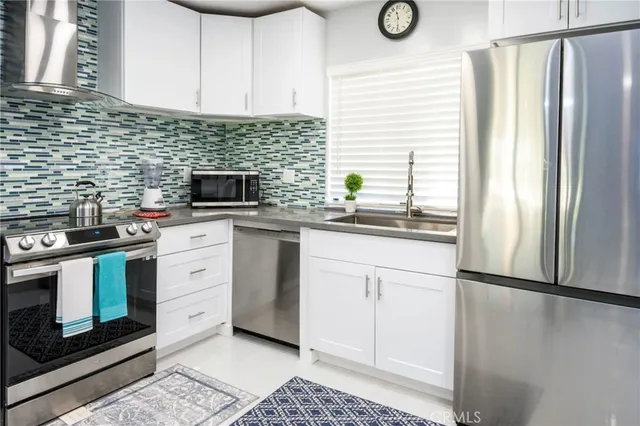 a kitchen with stainless steel appliances granite countertop a stove a refrigerator and a cabinets