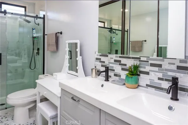 a bathroom with a sink a toilet and shower