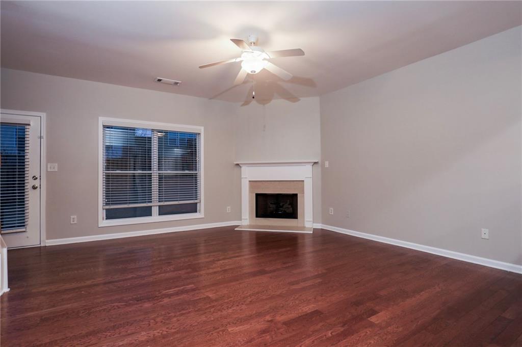 346 Beynon Terrace Suwanee, GA 30024 - Photo 2 of 17 a view of an empty room with wooden floor fireplace and a window