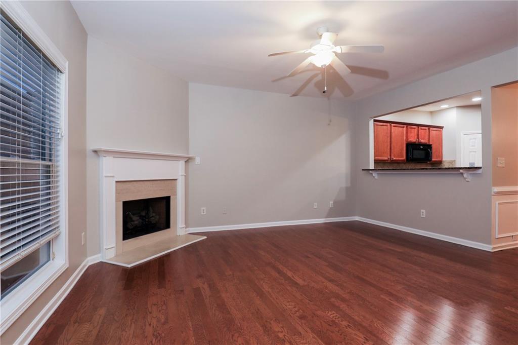 346 Beynon Terrace Suwanee, GA 30024 - Photo 3 of 17 a view of a livingroom with a fireplace wooden floor a chandelier and windows