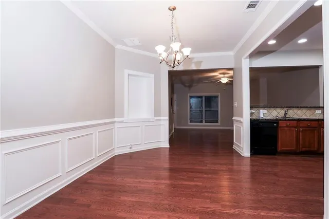 a view of a kitchen with granite countertop a stove top oven a sink and dishwasher with wooden floor