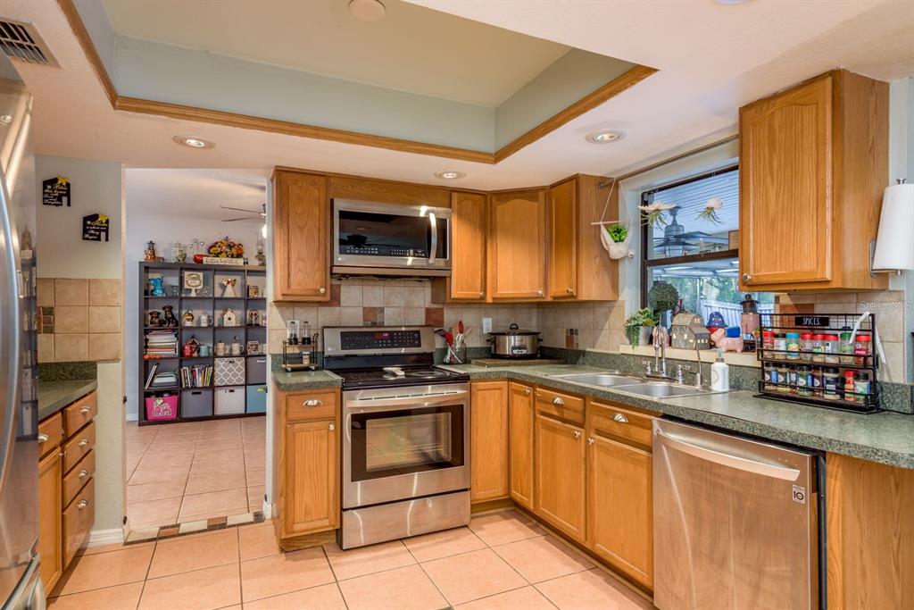 7487 Alhambra Court Spring Hill, FL 34606 - Photo 16 of 61 a kitchen with stainless steel appliances granite countertop a stove microwave and sink