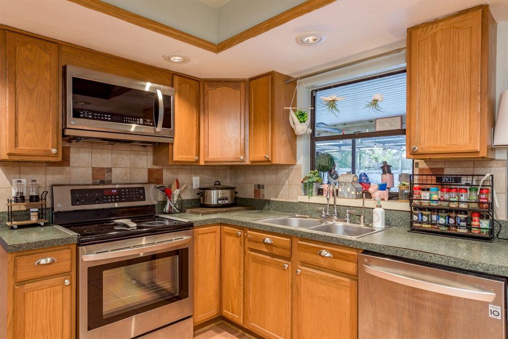 7487 Alhambra Court Spring Hill, FL 34606 - Photo 17 of 61 a kitchen with stainless steel appliances granite countertop a stove a sink and a microwave