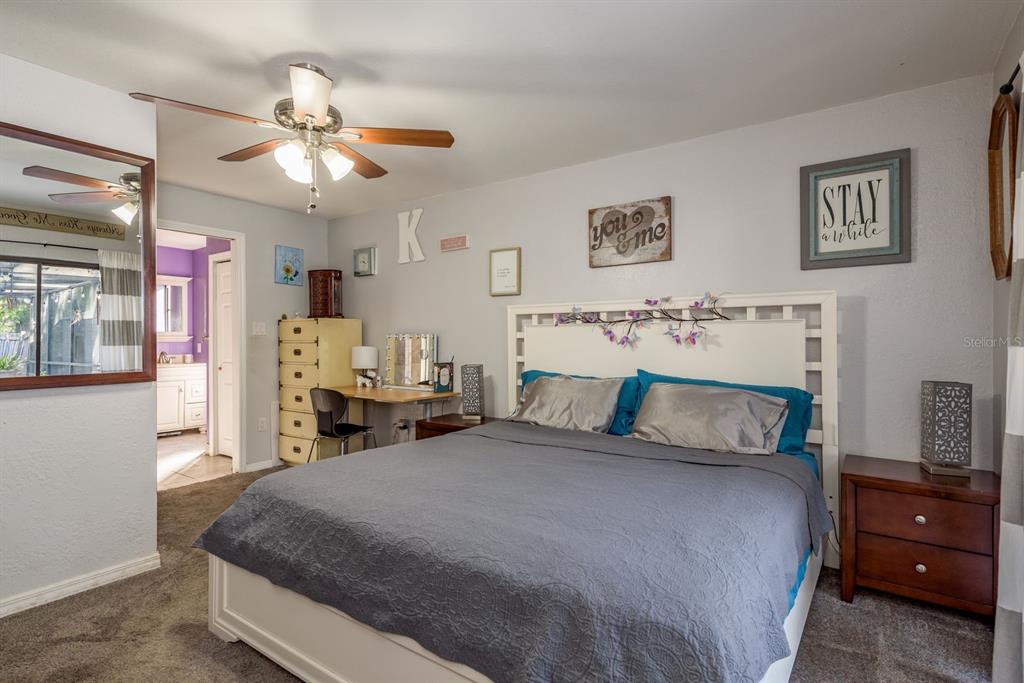 7487 Alhambra Court Spring Hill, FL 34606 - Photo 25 of 61 a bedroom with a bed and a chandelier