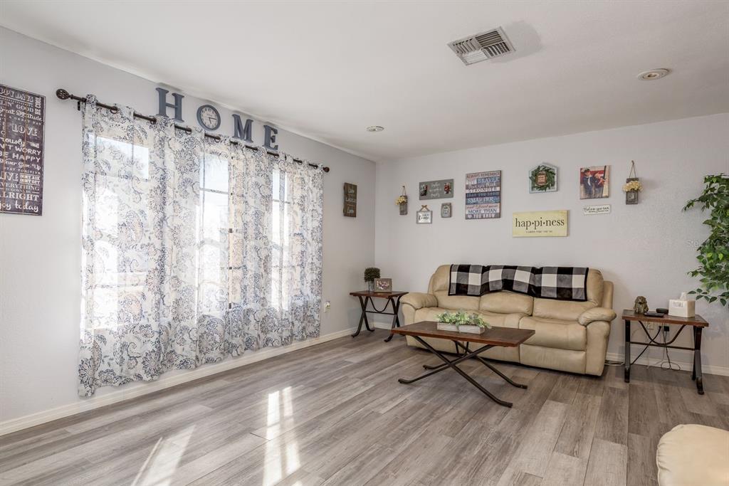 7487 Alhambra Court Spring Hill, FL 34606 - Photo 9 of 61 a living room with furniture and a wooden floor