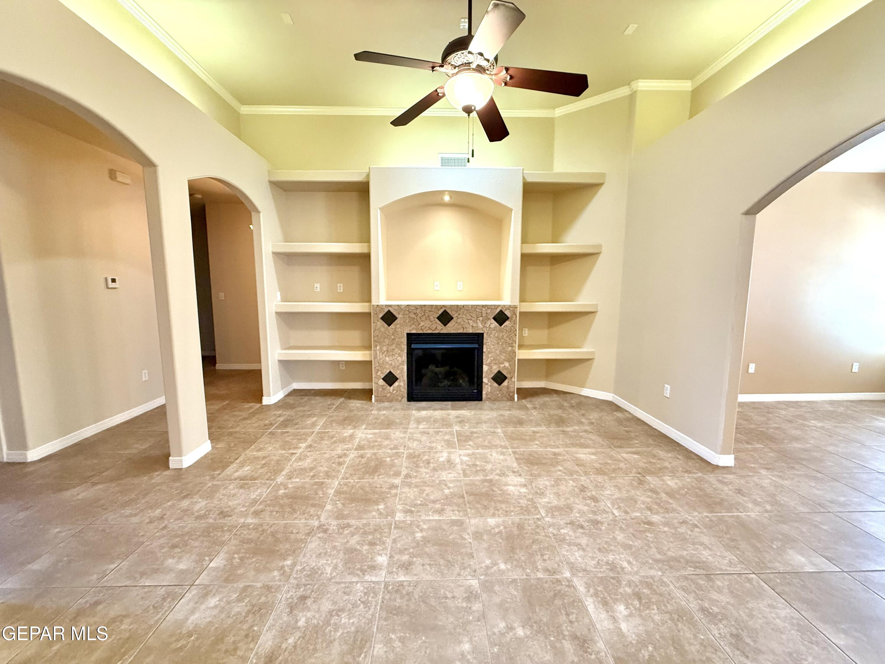 3060 Solar Point Lane El Paso, TX 79938 - Photo 13 of 49 a view of a room with a fireplace and a ceiling fan