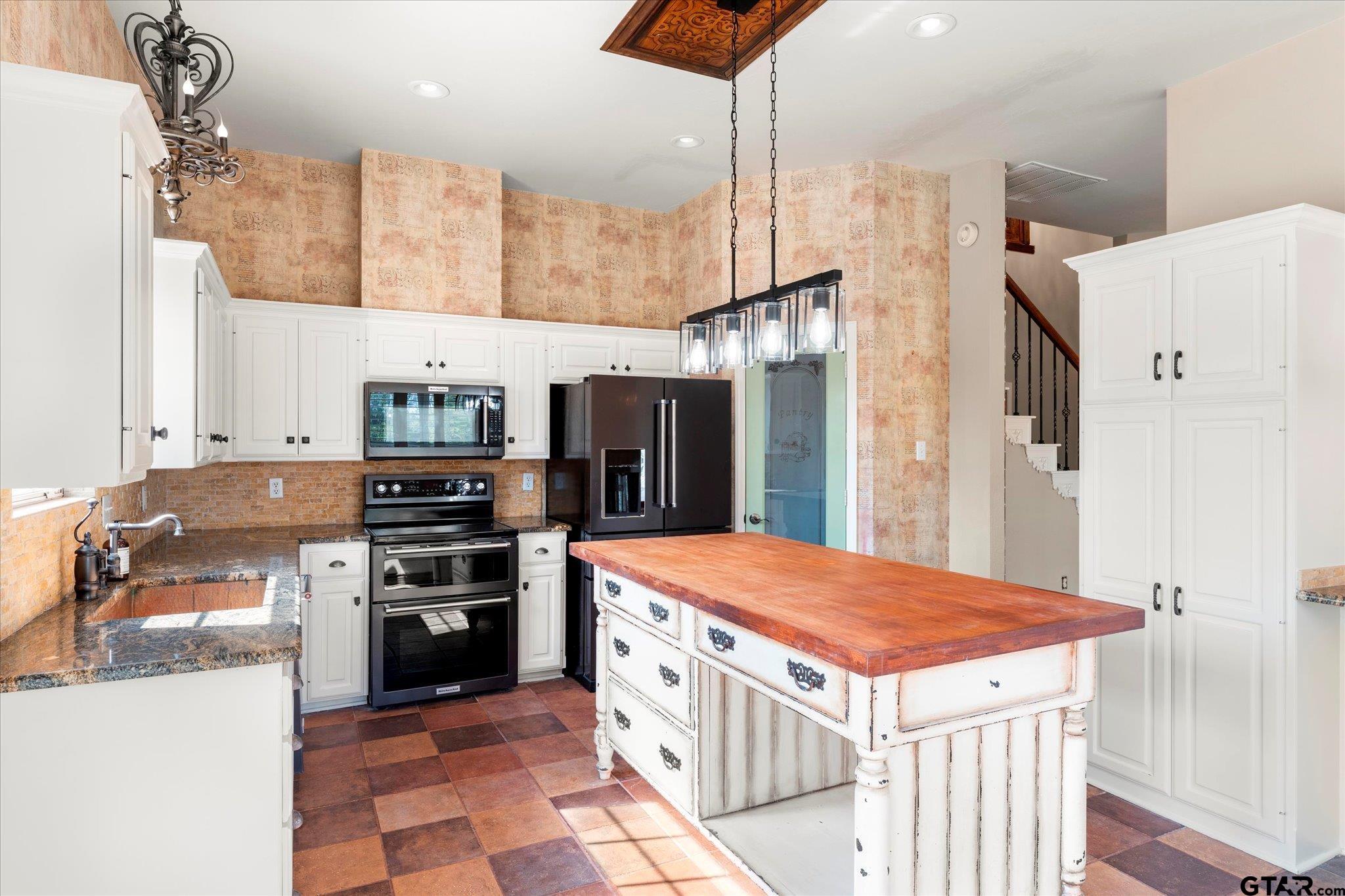 1879 Fig Road Gilmer, TX 75645 - Photo 18 of 46 a kitchen with stainless steel appliances kitchen island granite countertop a refrigerator a stove and a sink