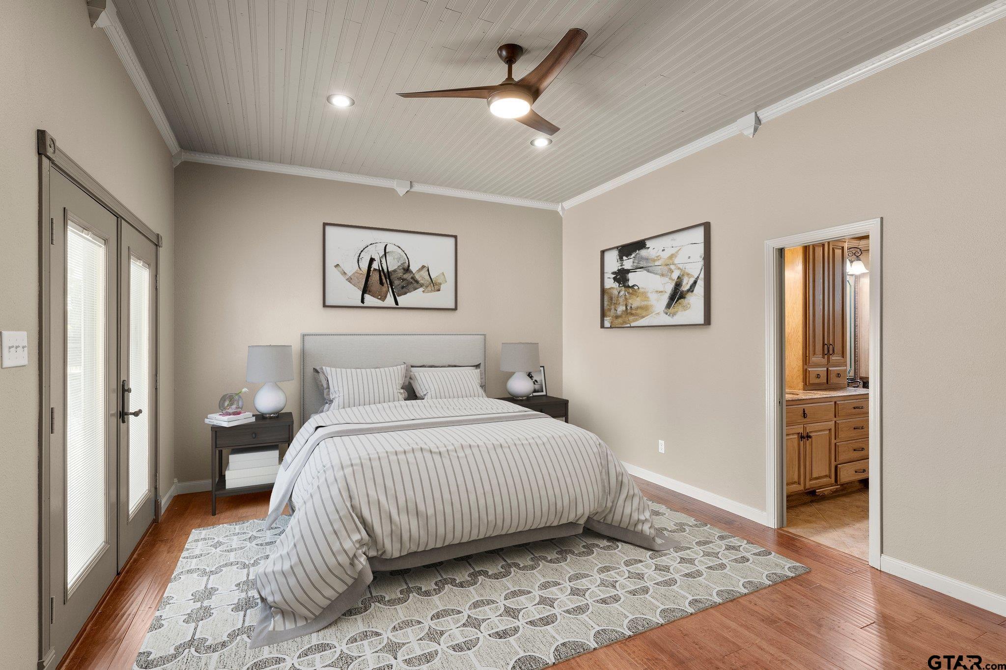 1879 Fig Road Gilmer, TX 75645 - Photo 20 of 46 a bedroom with a large bed and a chandelier