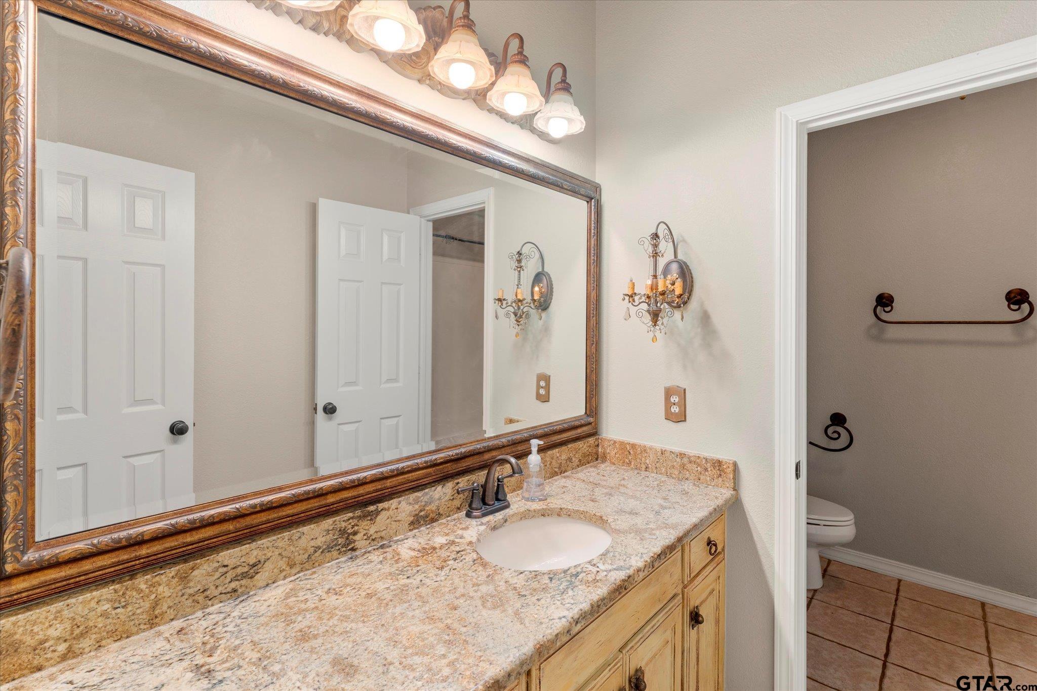 1879 Fig Road Gilmer, TX 75645 - Photo 29 of 46 a bathroom with a granite countertop sink and a mirror