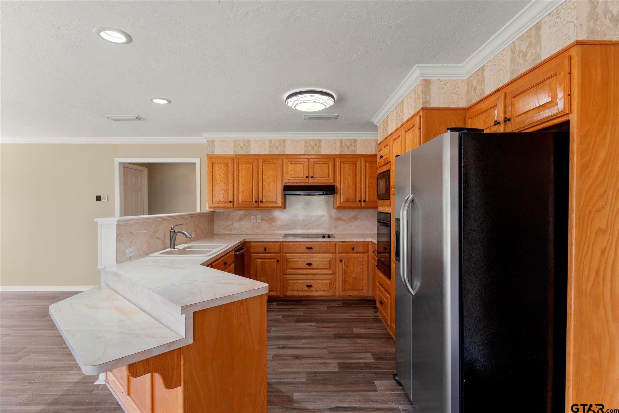 1879 Fig Road Gilmer, TX 75645 - Photo 34 of 46 a large kitchen with stainless steel appliances granite countertop a refrigerator a oven and a stove with wooden floor