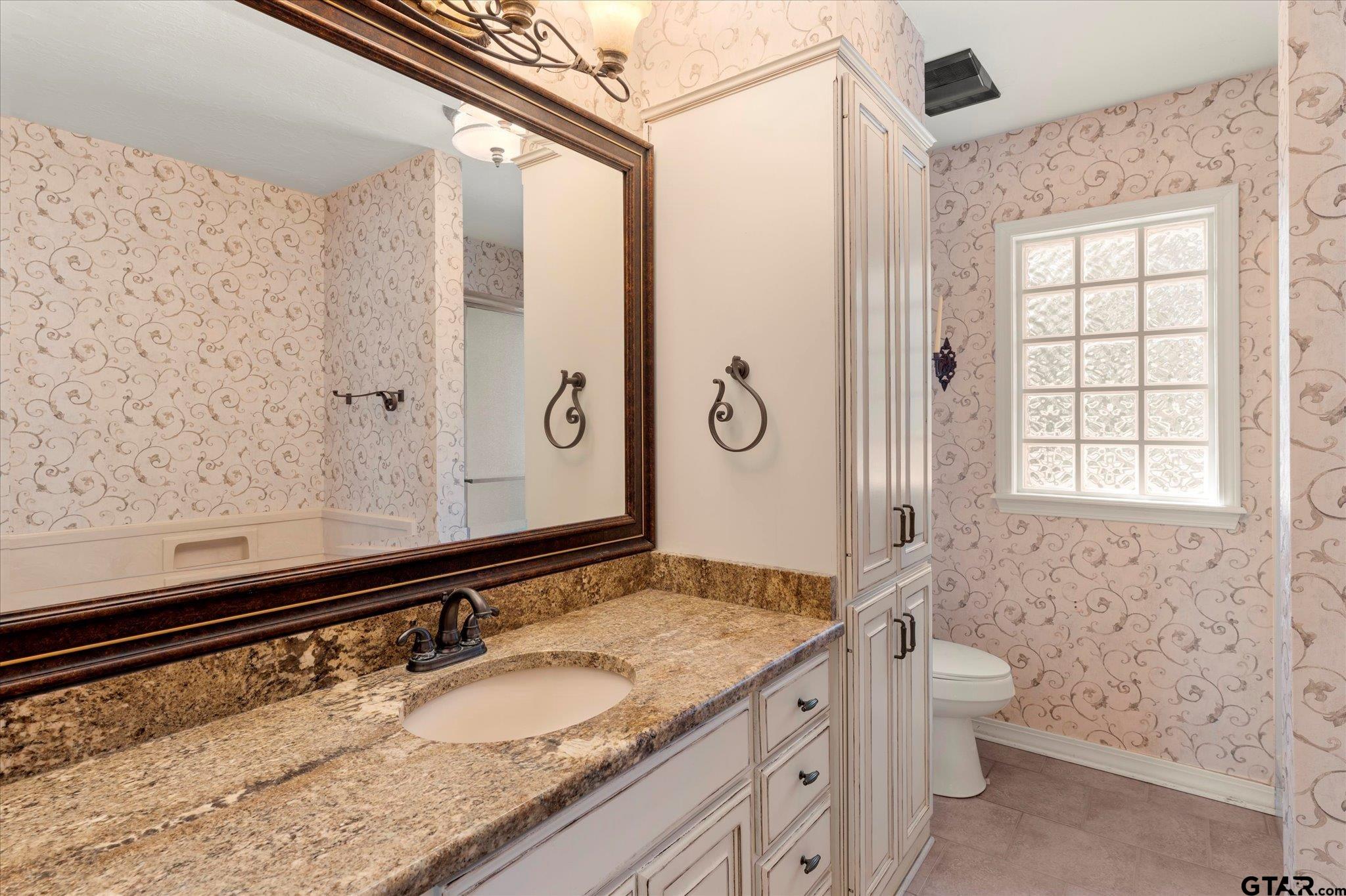 1879 Fig Road Gilmer, TX 75645 - Photo 36 of 46 a bathroom with a granite countertop sink toilet and shower