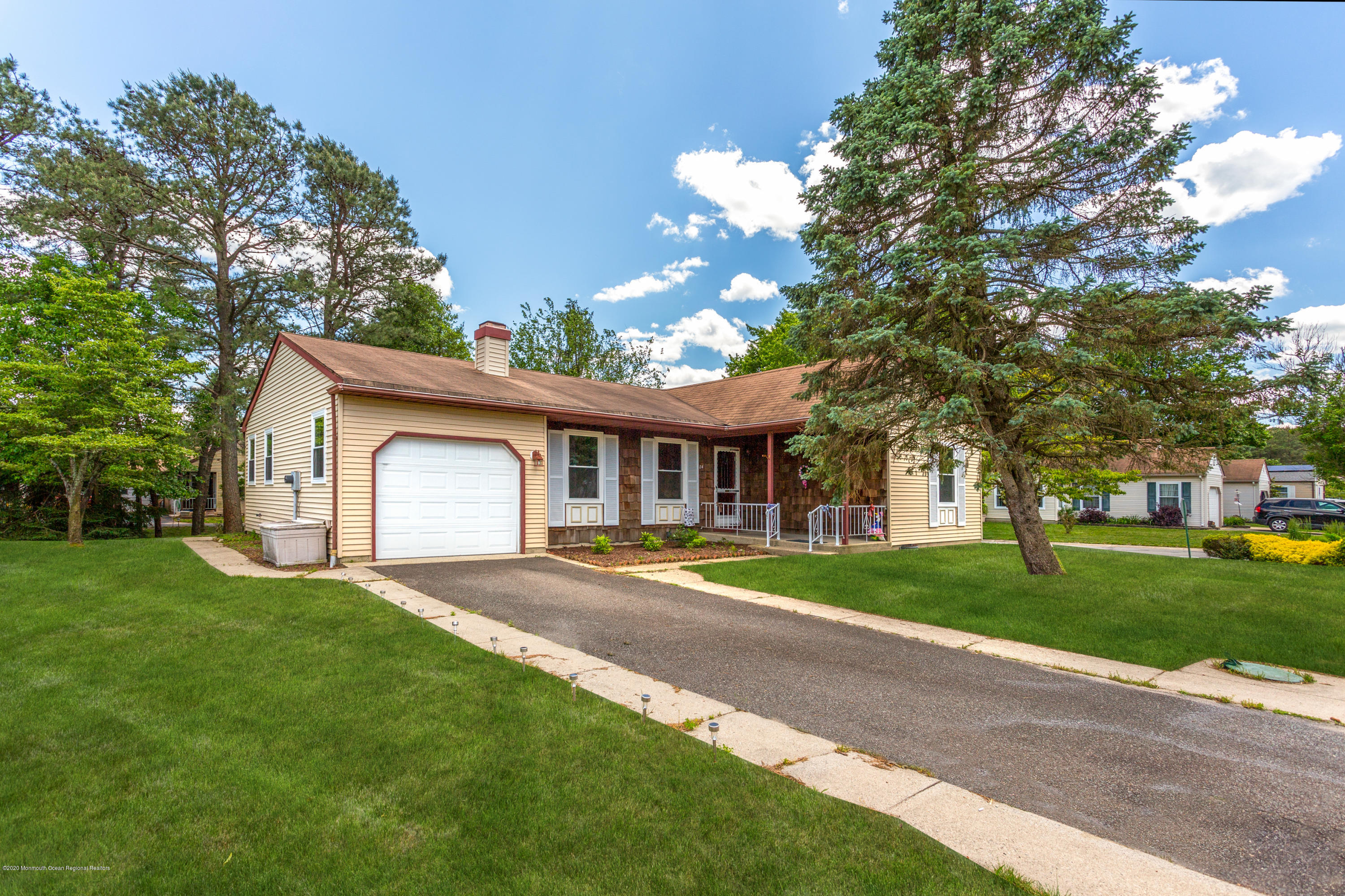 84 Sunset Road, Unit 60 Whiting, NJ 08759 - Photo 2 of 51 a front view of a house with a yard and garage