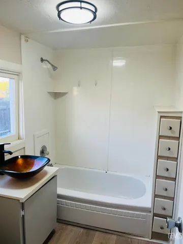 a bathroom with a tub a sink and a shower