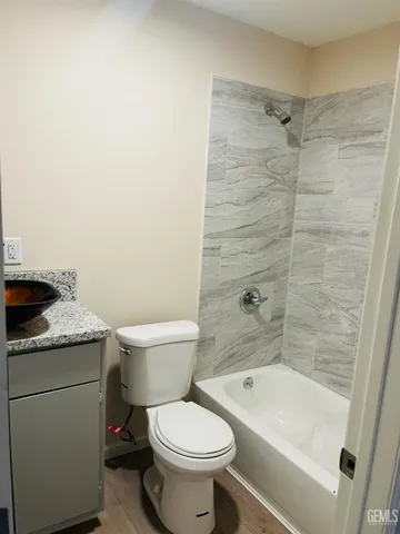a bathroom with a granite countertop toilet a sink and bathtub