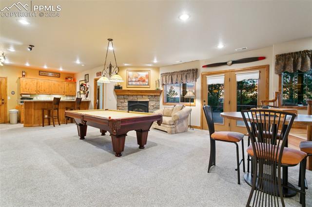 5470 Roundup Ridge Road Colorado Springs, CO 80908 - Photo 16 of 21 Playroom with light carpet, pool table, french doors, and a fireplace