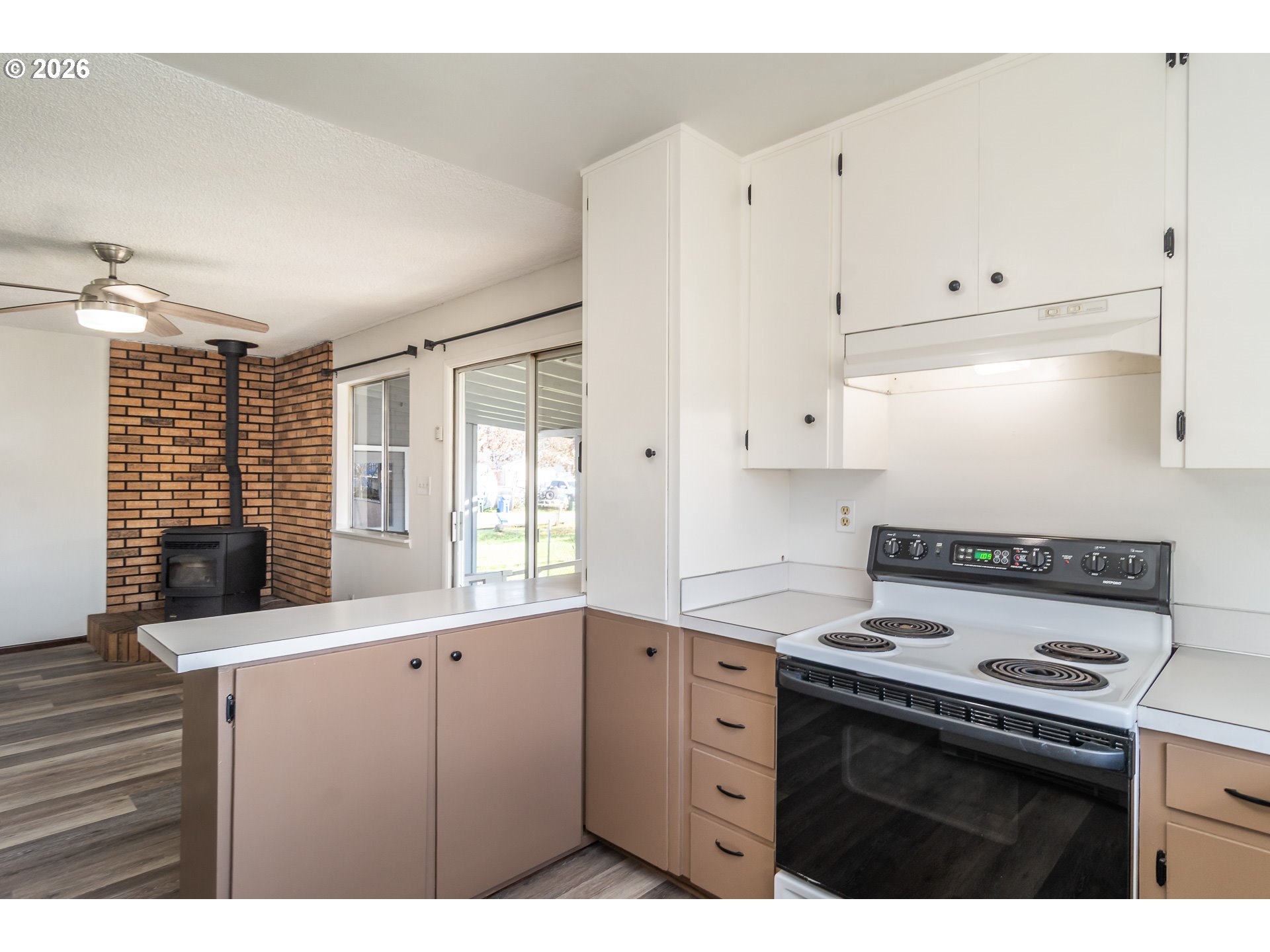 219 Hawthorne Street Sutherlin, OR 97479 - Photo 13 of 45 a kitchen with granite countertop a stove a sink and white cabinets