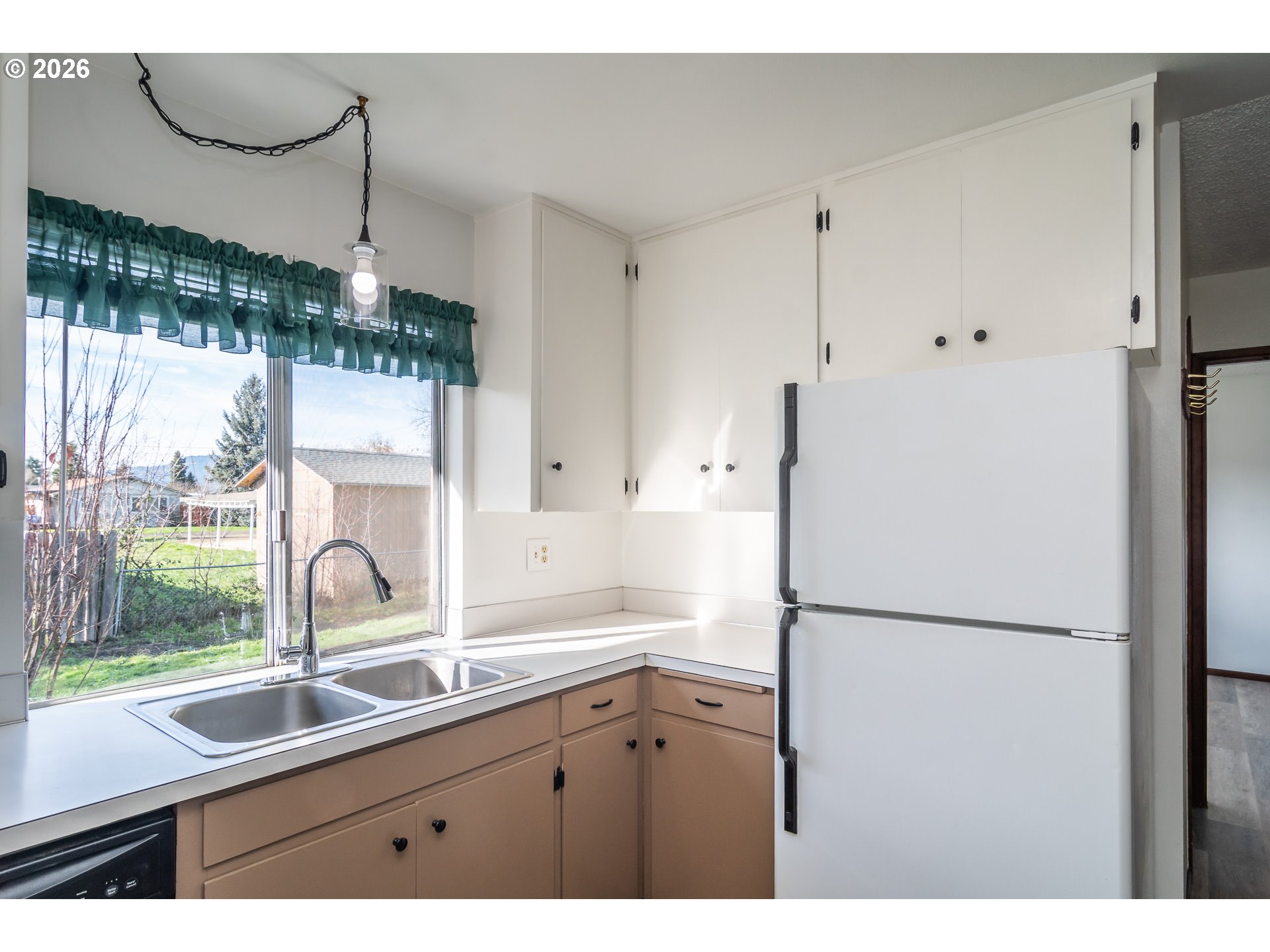 219 Hawthorne Street Sutherlin, OR 97479 - Photo 14 of 45 a kitchen with a sink and a refrigerator