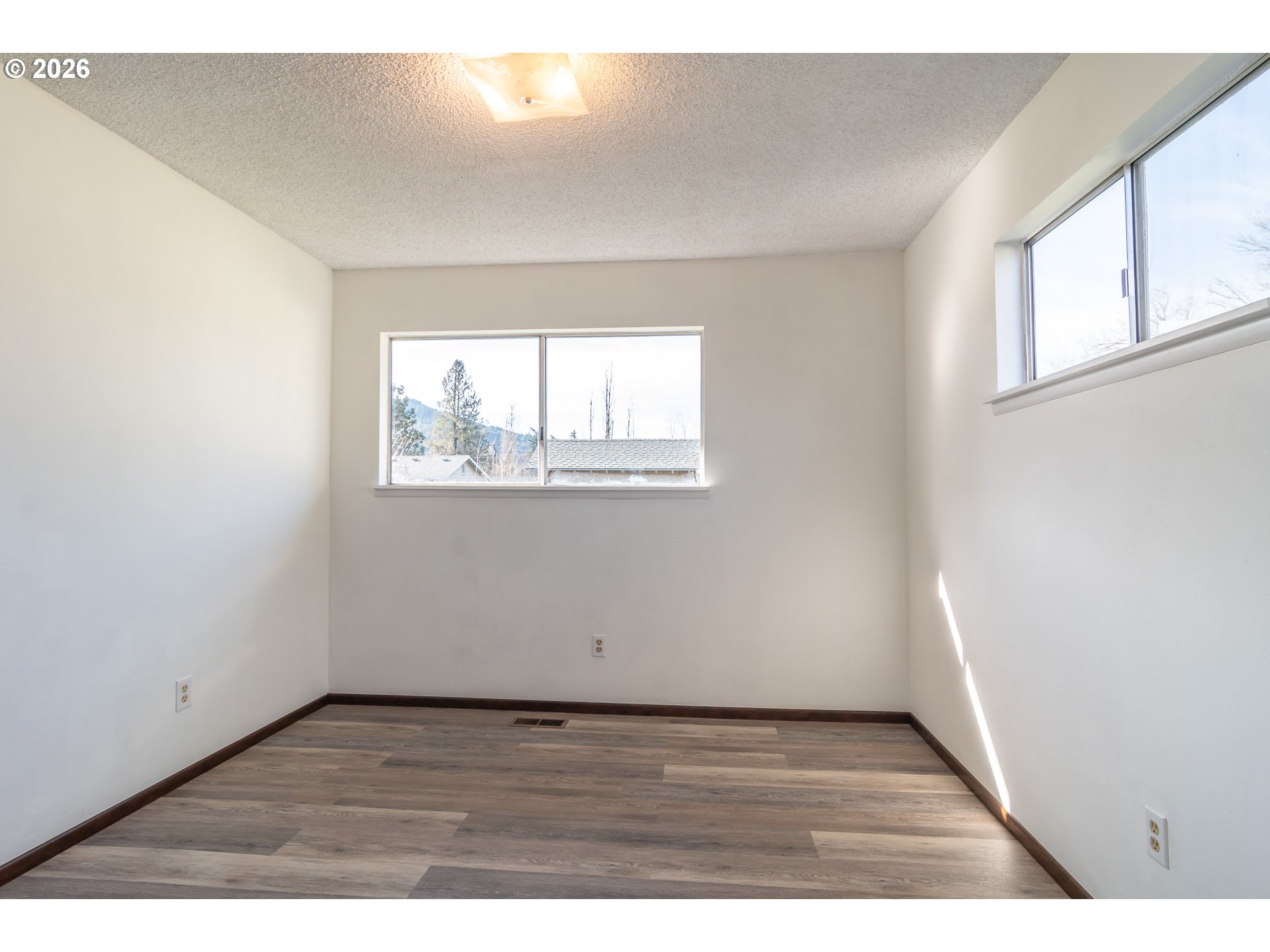 219 Hawthorne Street Sutherlin, OR 97479 - Photo 27 of 45 an empty room with wooden floor and windows