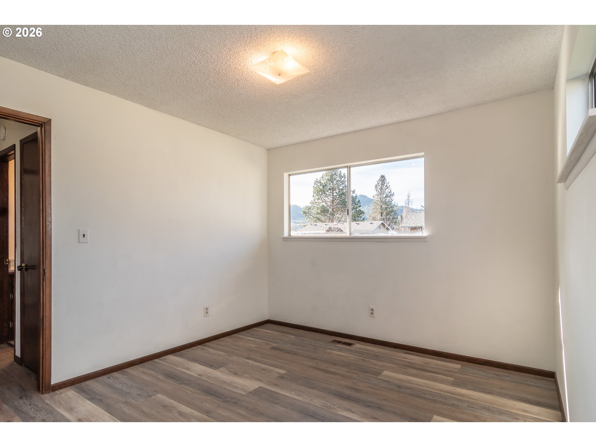 219 Hawthorne Street Sutherlin, OR 97479 - Photo 28 of 45 an empty room with wooden floor and windows