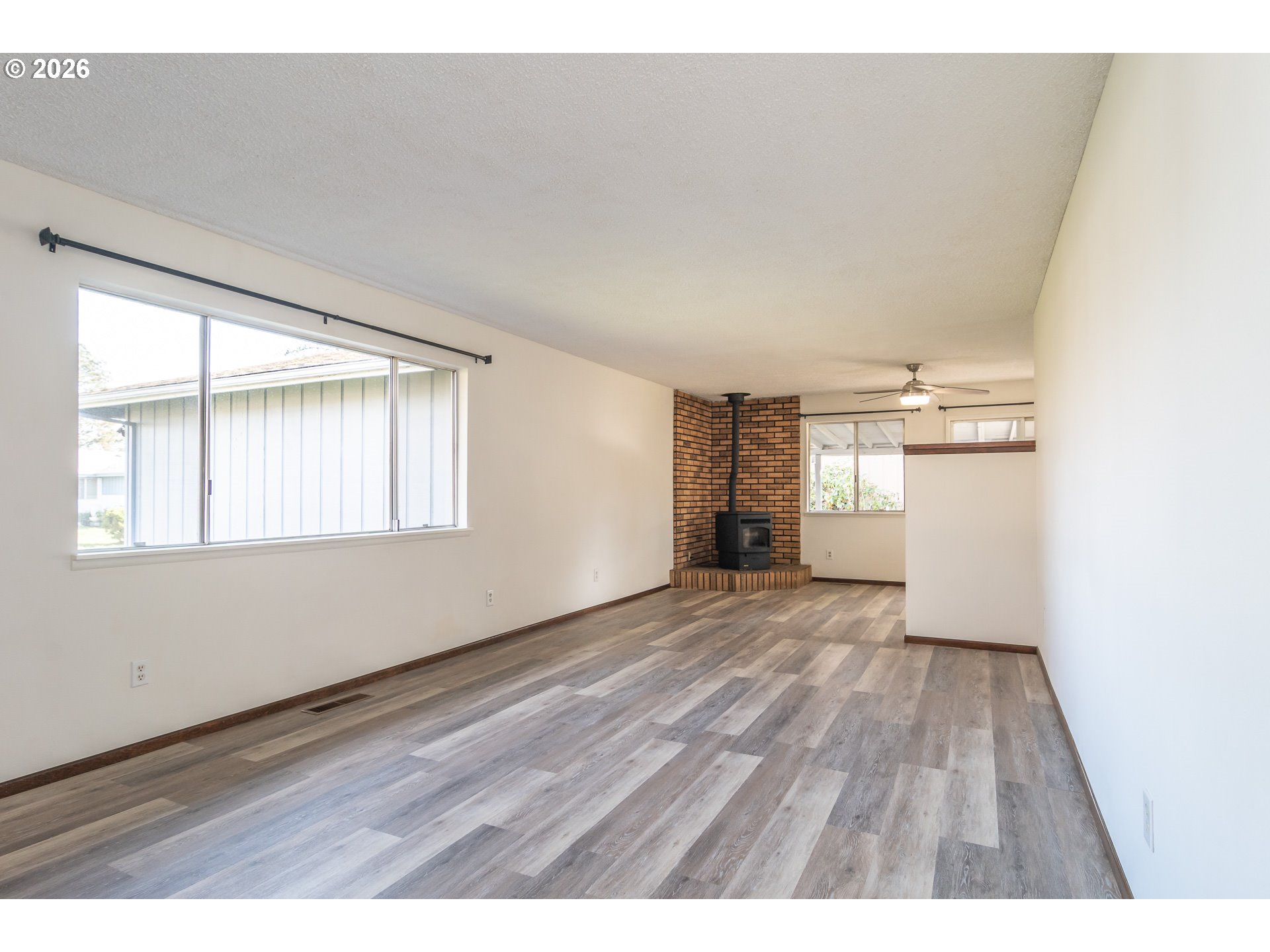 219 Hawthorne Street Sutherlin, OR 97479 - Photo 4 of 45 a view of an empty room with wooden floor and a window