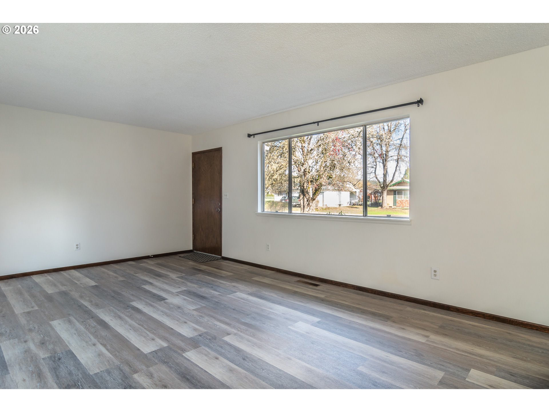 219 Hawthorne Street Sutherlin, OR 97479 - Photo 8 of 45 an empty room with wooden floor and windows