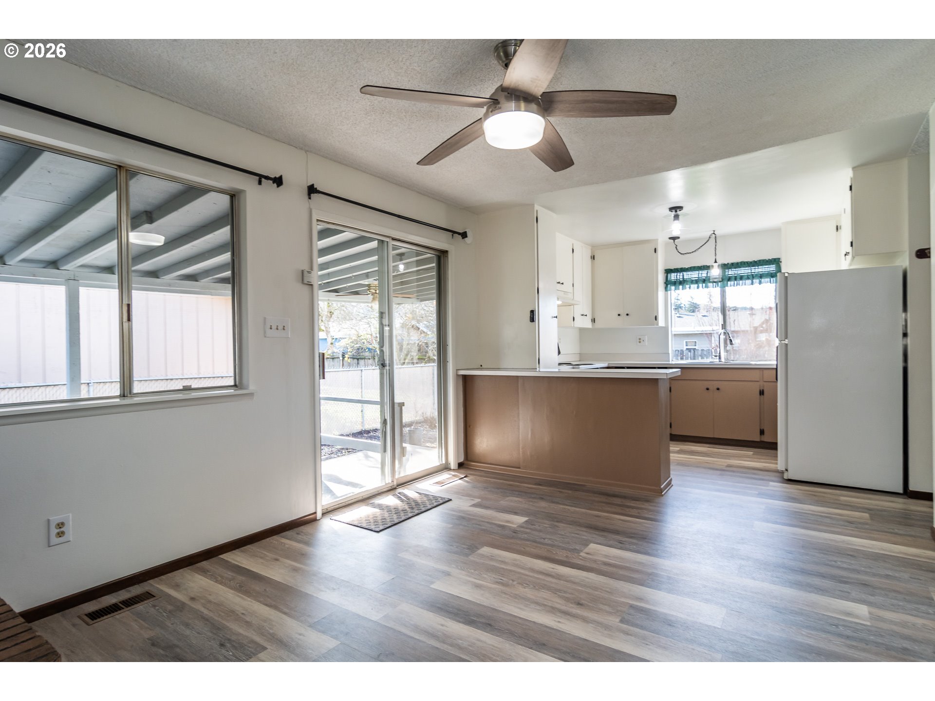219 Hawthorne Street Sutherlin, OR 97479 - Photo 9 of 45 a view interior of a house wooden floor a ceiling fan and windows