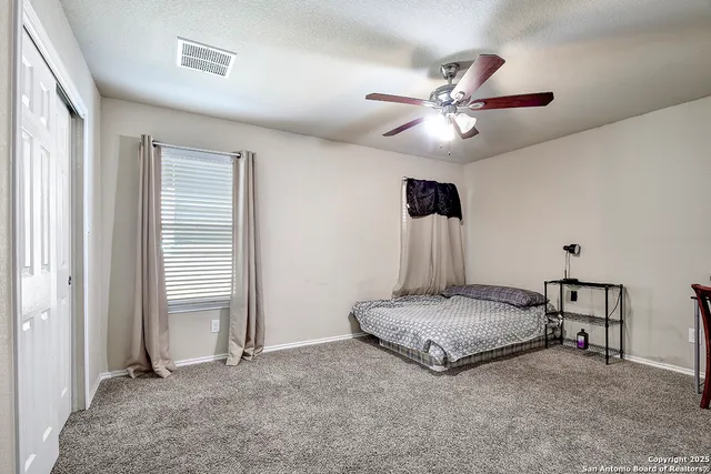 a spacious bedroom with a bed and a chandelier
