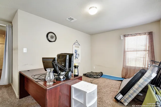 a view of a workspace with furniture and a window