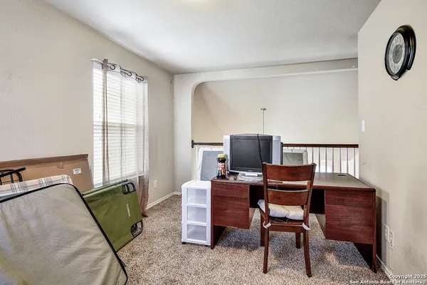 a view of a workspace with furniture and a window