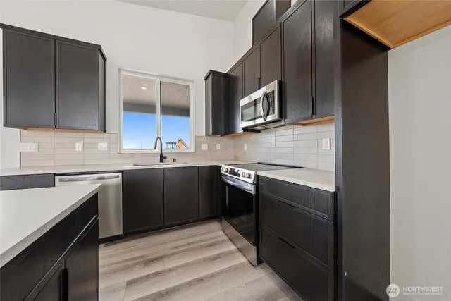 a kitchen with stainless steel appliances granite countertop a sink and stove top oven